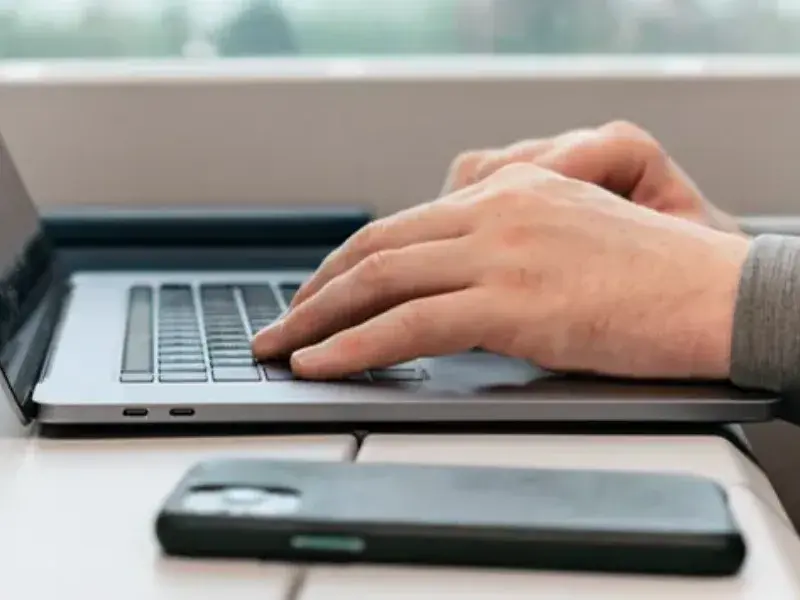 Laptop och mobiltelefon på ett skrivbord