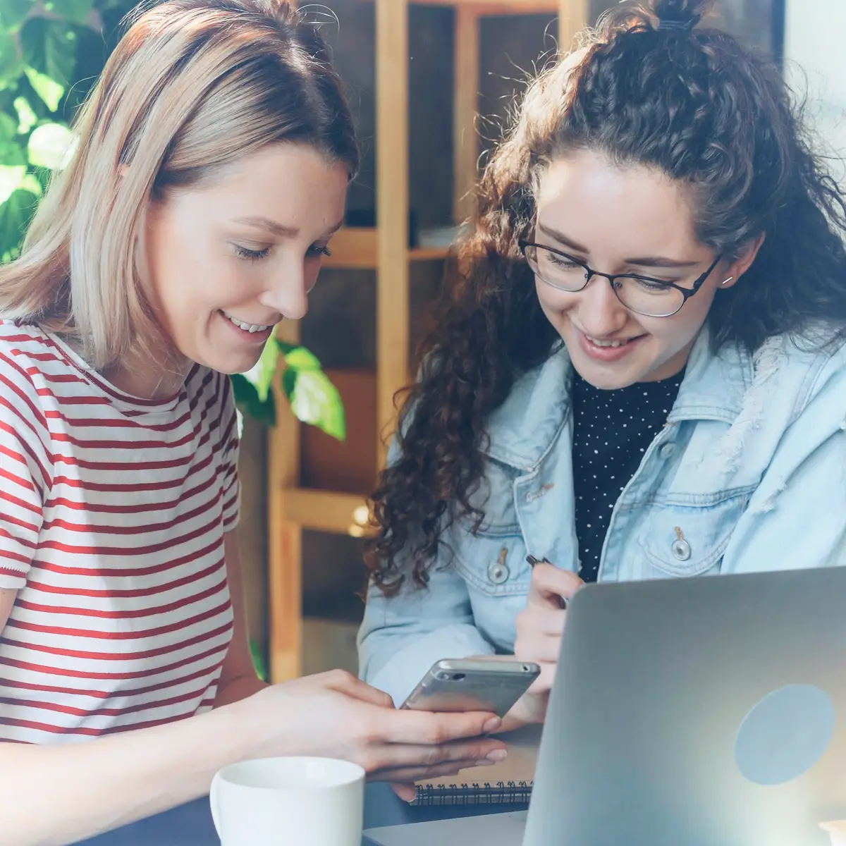 Två kvinnor jämför mobilabonnemang